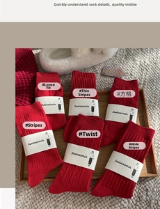 Detail of red cotton socks with six different textures like cables and stripes in a tray