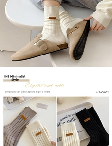 Detailed close-up of ribbed cotton crew socks featuring a decorative brown leather patch