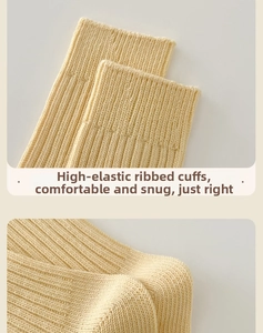 Detail of high-elastic ribbed cuffs on cream knitted socks showing vertical texture