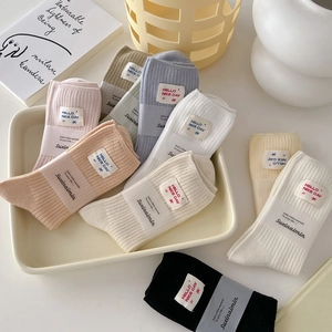 Vertical striped ribbed cotton mid-calf socks in assorted macaron colors with fabric label