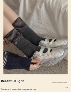 Close-up of gray striped cotton socks featuring vintage buttons and silver Mary Jane shoes
