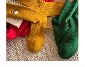 Macro detail of Christmas socks with embroidery on textured knit fabric for gifts