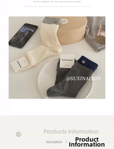 Detailed shot of two-tone combed cotton socks with decorative buttons on a white tray