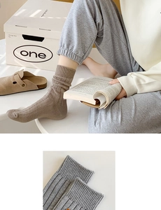 Detailed close-up of ribbed knit texture on stylish grey mid-calf length cotton socks