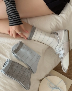Detail of Korean-style striped mid-calf socks featuring retro lettuce trim and cotton texture