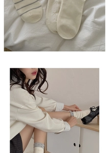 Detail view of cream mid-calf socks with stripes, dots and bow embroidery details