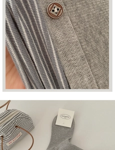 Detail of grey ribbed cotton socks featuring decorative fashion buttons and brand tag