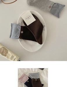 Detail view of cotton striped socks with vintage wooden buttons and ribbed knit texture