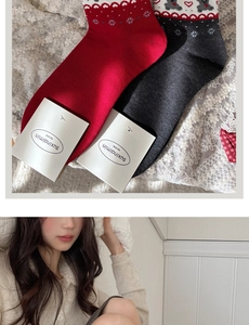 Detail of grey and red knit socks with Christmas heart and snowflake patterns
