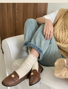 Brown leather loafers with gold floral buckle paired with frilly crew socks