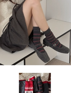 Close-up of gray Fair Isle crew socks with red bear patterns and Mary Jane wool shoes