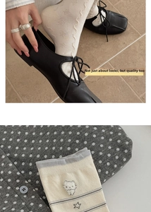 Detail of white cotton mid-calf socks with cute embroidered cat and star patterns