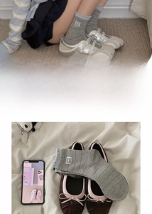 Close-up of grey striped cotton socks with ruffled edges and panda patch detail