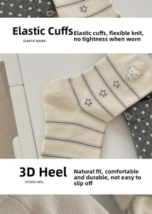 Detail of cream kids socks with grey stripes, plush bear patch and elastic cuffs
