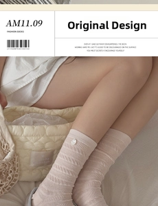 Detail of apricot pink knit mid-calf socks with button accents and cable stitch texture