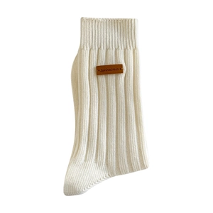 Off-white ribbed mid-tube knit socks featuring a stylish brown leather logo patch