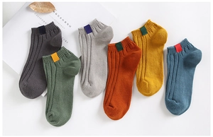 Detail view of colorful ribbed cotton ankle socks with decorative ankle tags