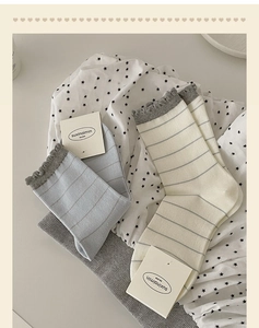 Detail of striped cotton socks featuring delicate wavy lettuce edges and soft ribbing