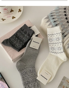 Dettaglio di tre paia di calze in cotone pettinato grigio e beige con motivi di orsi