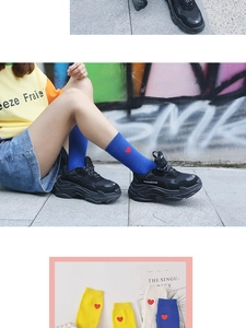 Détail de chaussettes en coton avec broderie cœur rouge en bleu, jaune et blanc