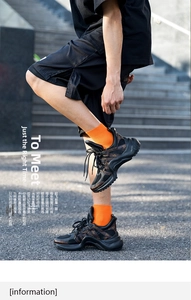 Close-up of thick-soled chunky sneakers with brown monogram pattern and orange socks