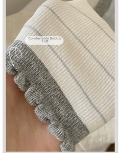 Detail of comfortable ruffled cuff on striped cotton socks with rib knit texture