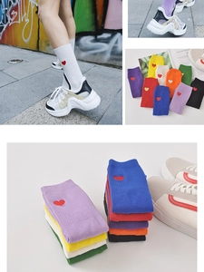 Détail de chaussettes en coton colorées avec broderie cœur rouge et bords côtelés