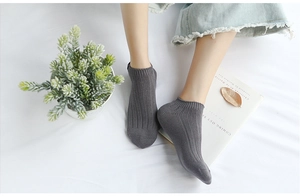 Detailed view of dark grey ribbed ankle socks in a minimalist lifestyle setting