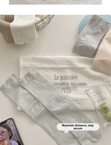Macro view of assorted pastel Tabi socks in a stylish home setting with metal basket