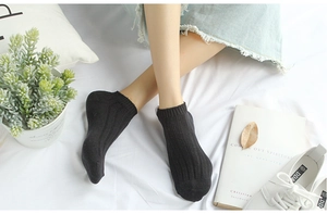 Close-up of black low-cut cotton socks with vertical ribbed knit and fabric label detail