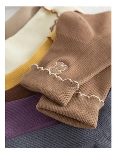 Close-up of ribbed knit cotton socks with cute bear embroidery and ruffle trim edges