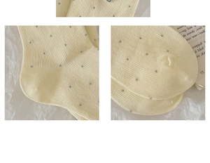 Detail showing beige ribbed cotton crew socks with grey polka dots and frilled cuffs