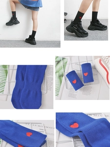 Détail de chaussettes mi-mollet bleues et noires avec broderie coeur rouge style preppy