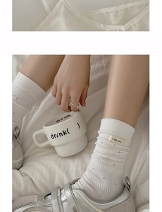 Detail of white cotton socks with gray dots and 'I dig you' label with silver sneakers