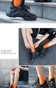 Detail of neon orange ribbed cotton socks paired with black monogram chunky sneakers