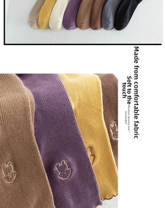Detailed close-up of ribbed cotton socks with cute cartoon rabbit embroidery and frill trim