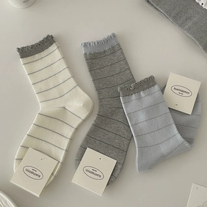 Three-pack cotton crew socks with gray stripes and ruffled lettuce edges in neutral tones