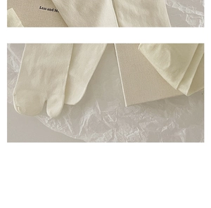 Detailed texture of off-white Tabi socks made of breathable silk knit fabric
