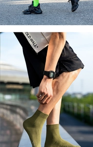 Close-up of olive green ribbed men's socks with white lettering in a street fashion style