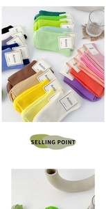 Flat lay of colorful Morandi cotton crew socks with minimalist brand tags and home decor