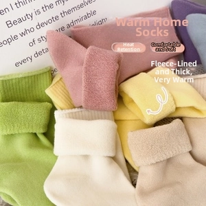 Stack of thick fleece thermal socks in assorted pastel colors for warm home wear