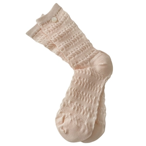 Pale pink crew socks with wavy knit texture and white button detail in a minimalist style