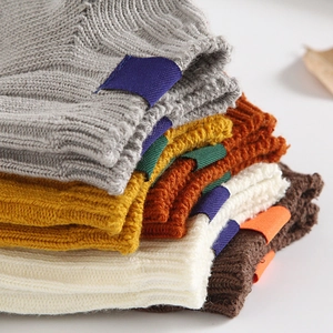 Chunky knit socks in warm autumn colors with aesthetic fabric tags on a white background