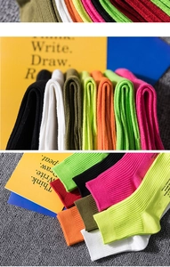 Close-up of vibrant ribbed knit crew socks with graphic text and vertical stripe texture