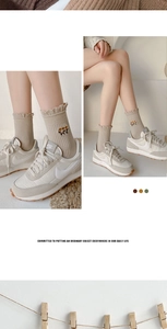 Detail of floral embroidery and ruffled cuff on ribbed knit crew socks in beige
