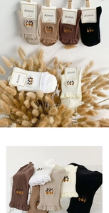 Detail of floral embroidery and lace ruffles on combed cotton mid-calf socks set