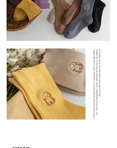 Detail of colorful ribbed cotton socks with ruffled edges and cute cartoon dog embroidery