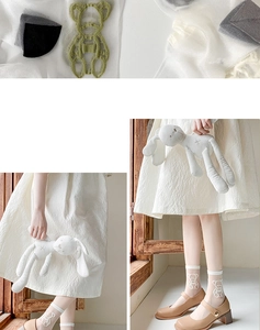 Detail of sheer white Lolita socks featuring green bear embroidery and thin mesh texture