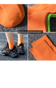 Close-up of vibrant orange and neon green ribbed cotton socks with letter printing