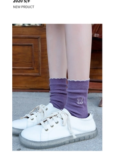Detail of purple ribbed cotton socks with white wavy edges and cute animal embroidery